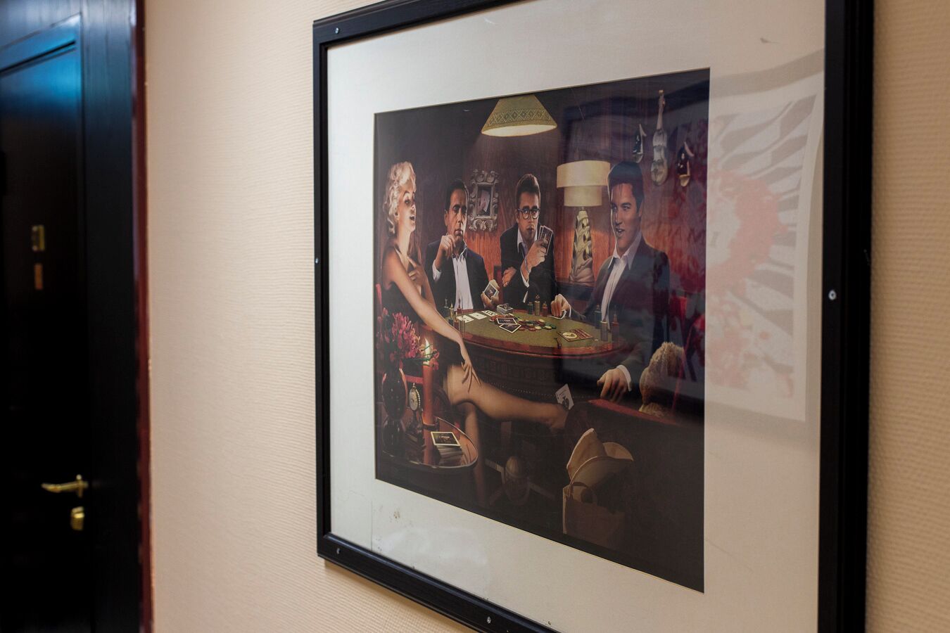 Una foto enmarcada de un grupo de personas jugando cartas en una mesa de casino.