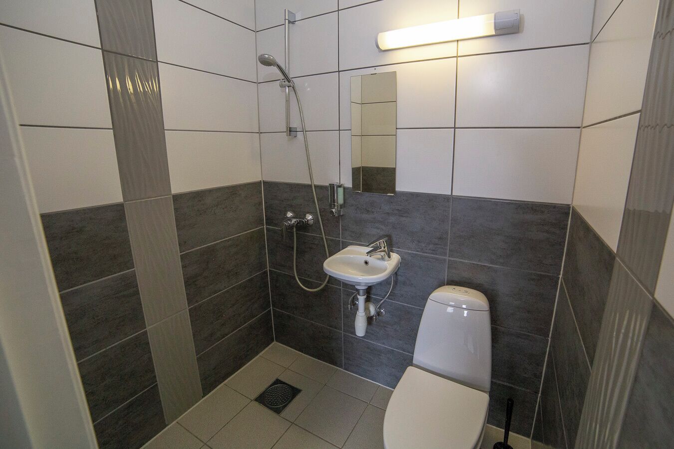 Ein Badezimmer mit Dusche, Waschbecken und Toilette.