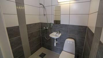 Ein Badezimmer mit Dusche, Waschbecken und Toilette.