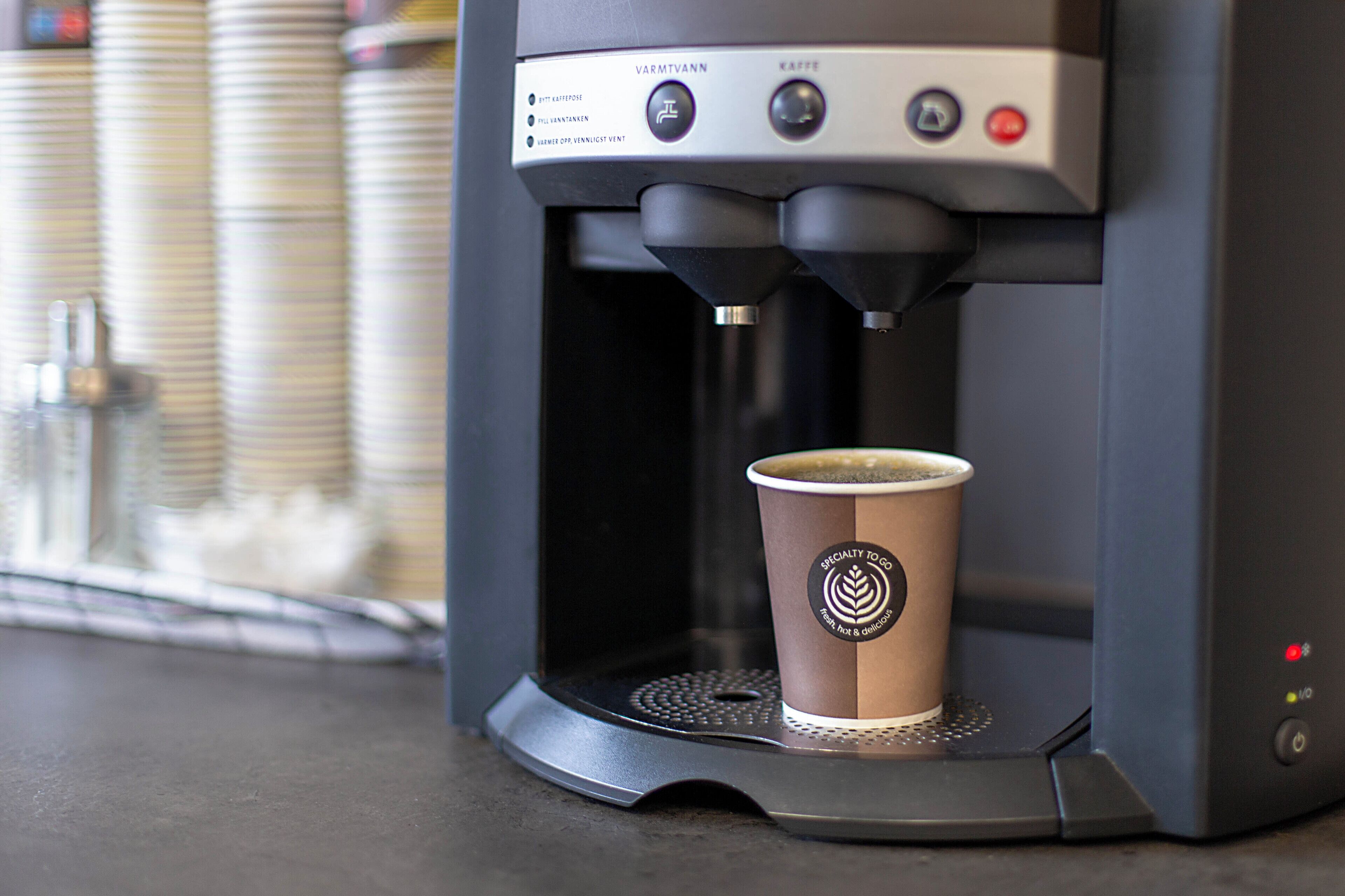 A coffee machine with a cup of coffee on its drip tray.
