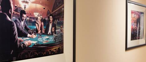 A framed photograph of a casino scene with a blackjack table, players, and a chandelier.
