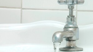 Une salle de bain avec un robinet chromé et un mur recouvert de carreaux blancs.