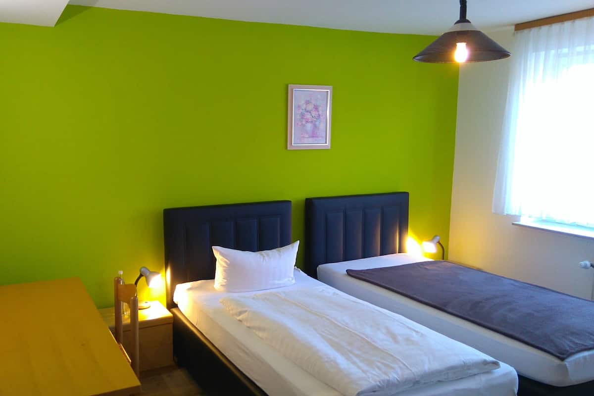 Une chambre avec deux lits, un bureau et une chaise.
