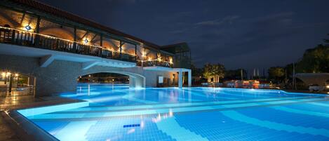 A large indoor swimming pool with a covered area and a bridge.