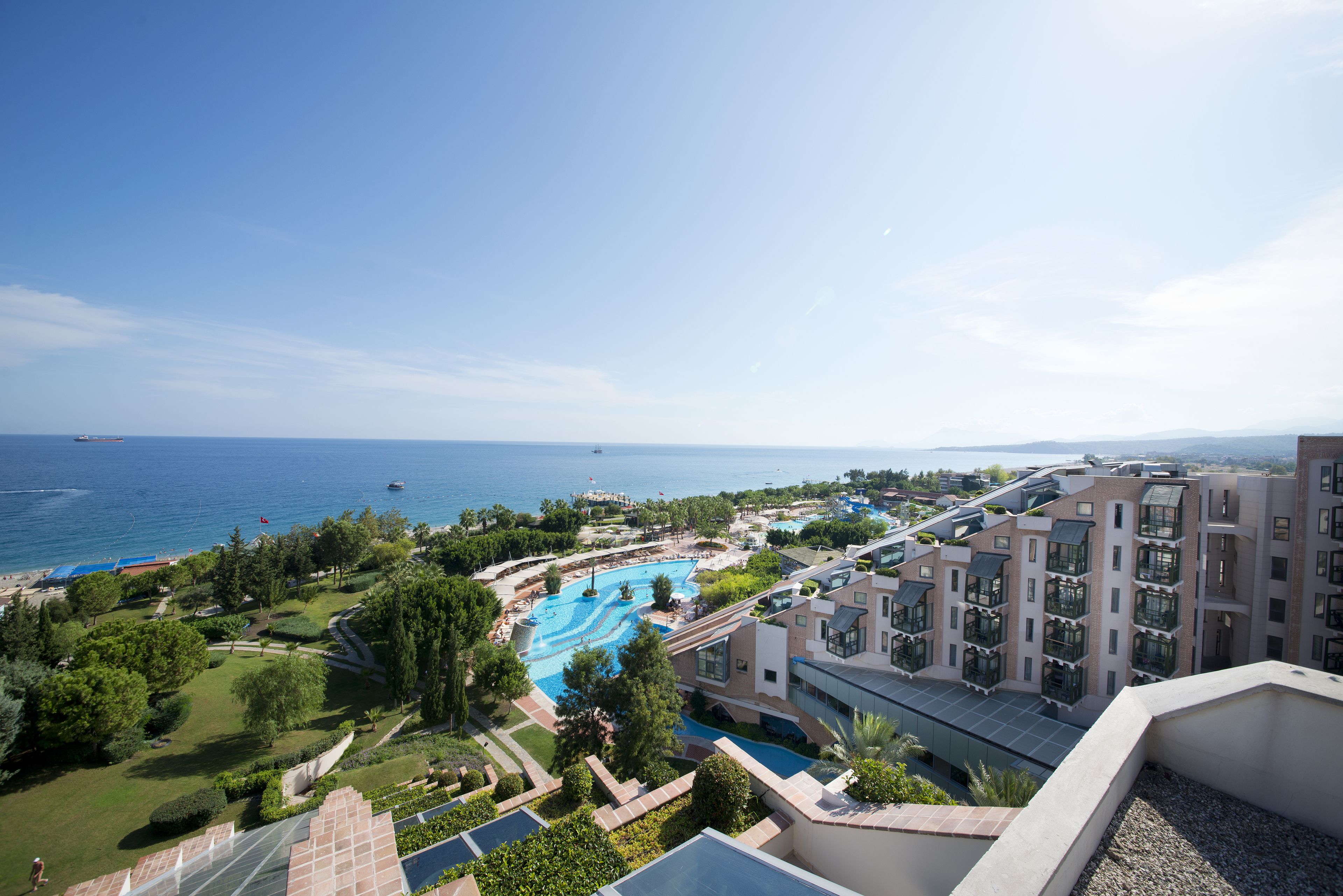 Un resort con piscina, jardines ajardinados y vistas al mar.