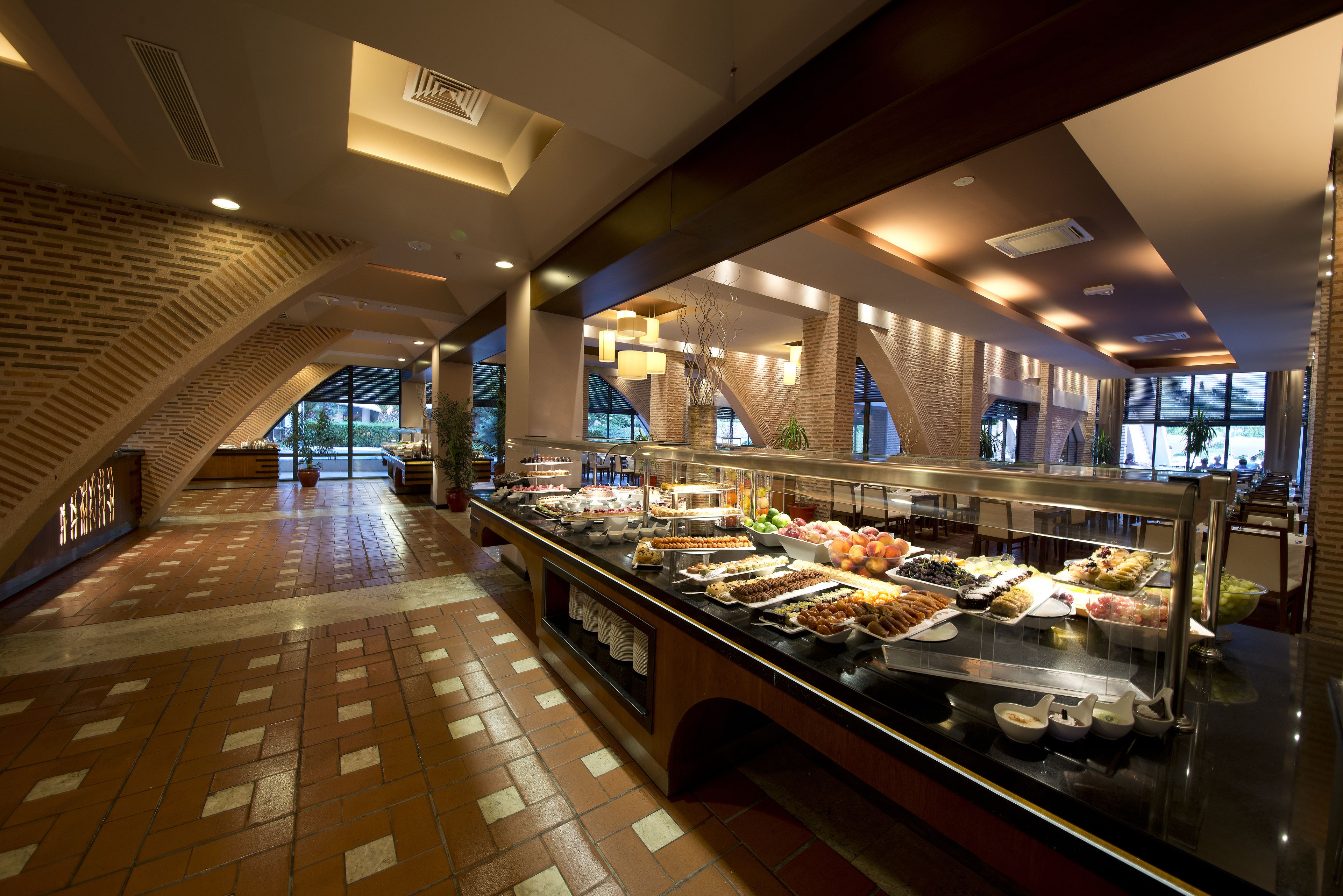 A buffet area with a variety of food options, a brick wall, and a staircase.