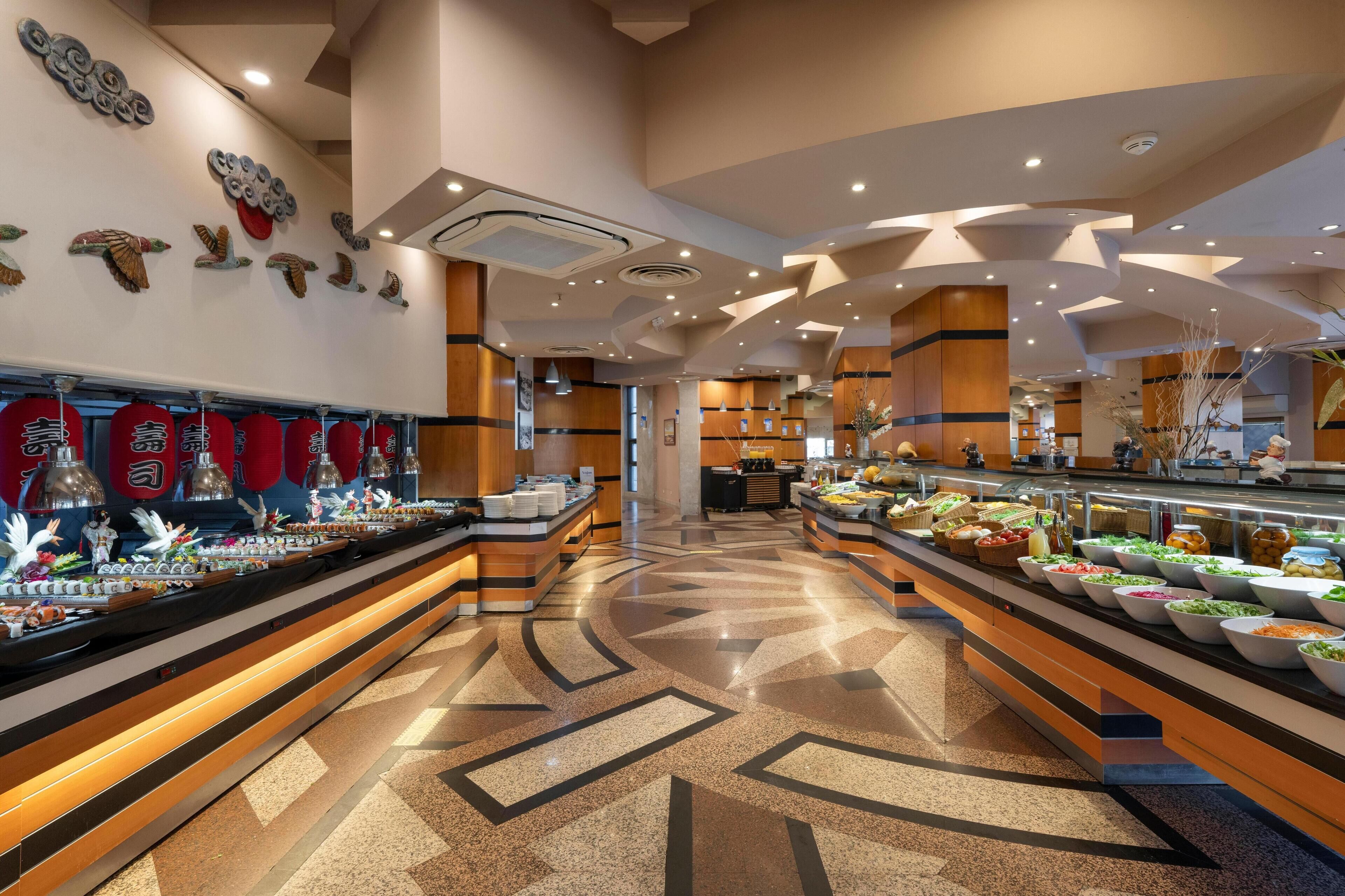 A buffet area with multiple food stations and decorative wall art.