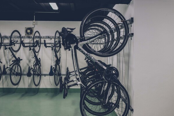 Zona de guardado para bicicletas con varias bicicletas colgadas en una pared.