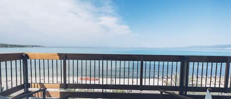 Un balcón con vista a una playa y el mar.