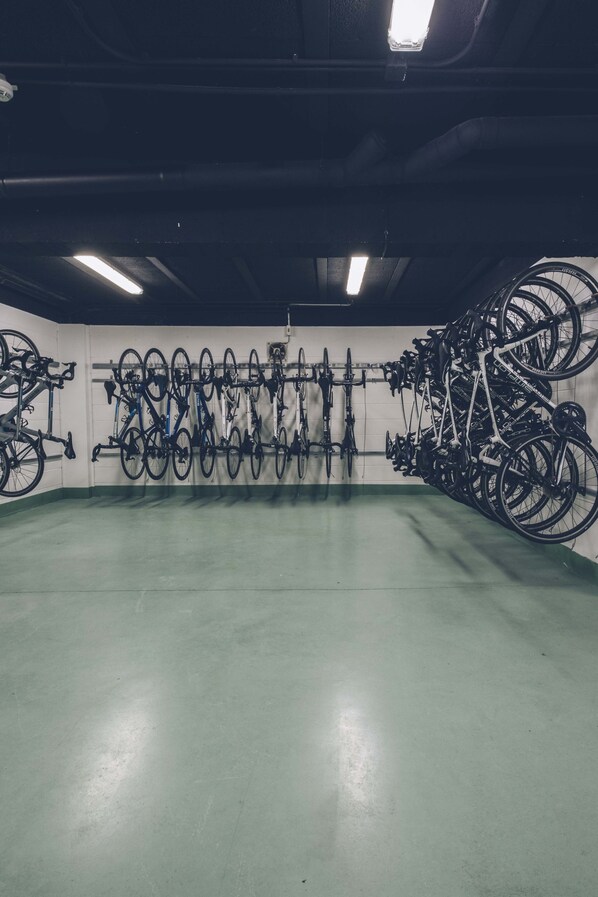 Zona de almacenamiento de bicicletas con varias bicicletas sujetas a estantes.