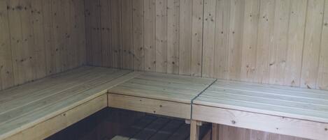 A wooden sauna with benches and a bench seat.