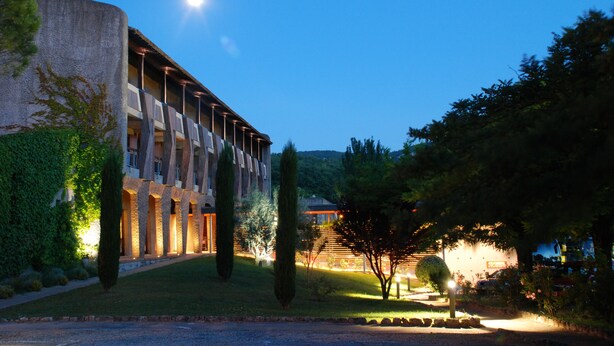 Un edificio de estilo arquitectónico moderno, con una serie de columnas y una entrada bien iluminada.