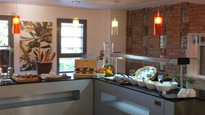 Una cocina con pared de ladrillo, lámparas colgantes y ventana con vistas a la vegetación.
