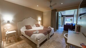 Una cama doble con cabecera, mesitas de noche y una pequeña mesa con una silla.