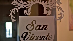 Une enseigne portant l  ’inscription « Hostal San Vicente II » et agrémentée d’éléments décoratifs.