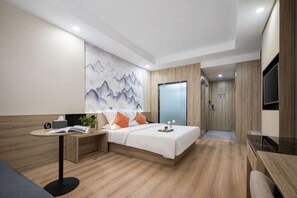 A modern hotel room with a bed, bedside table, and a desk with a chair. - Kaiyue Business Hotel(Ninefang City Shop,Northmen Road ) (KUNSHAN)