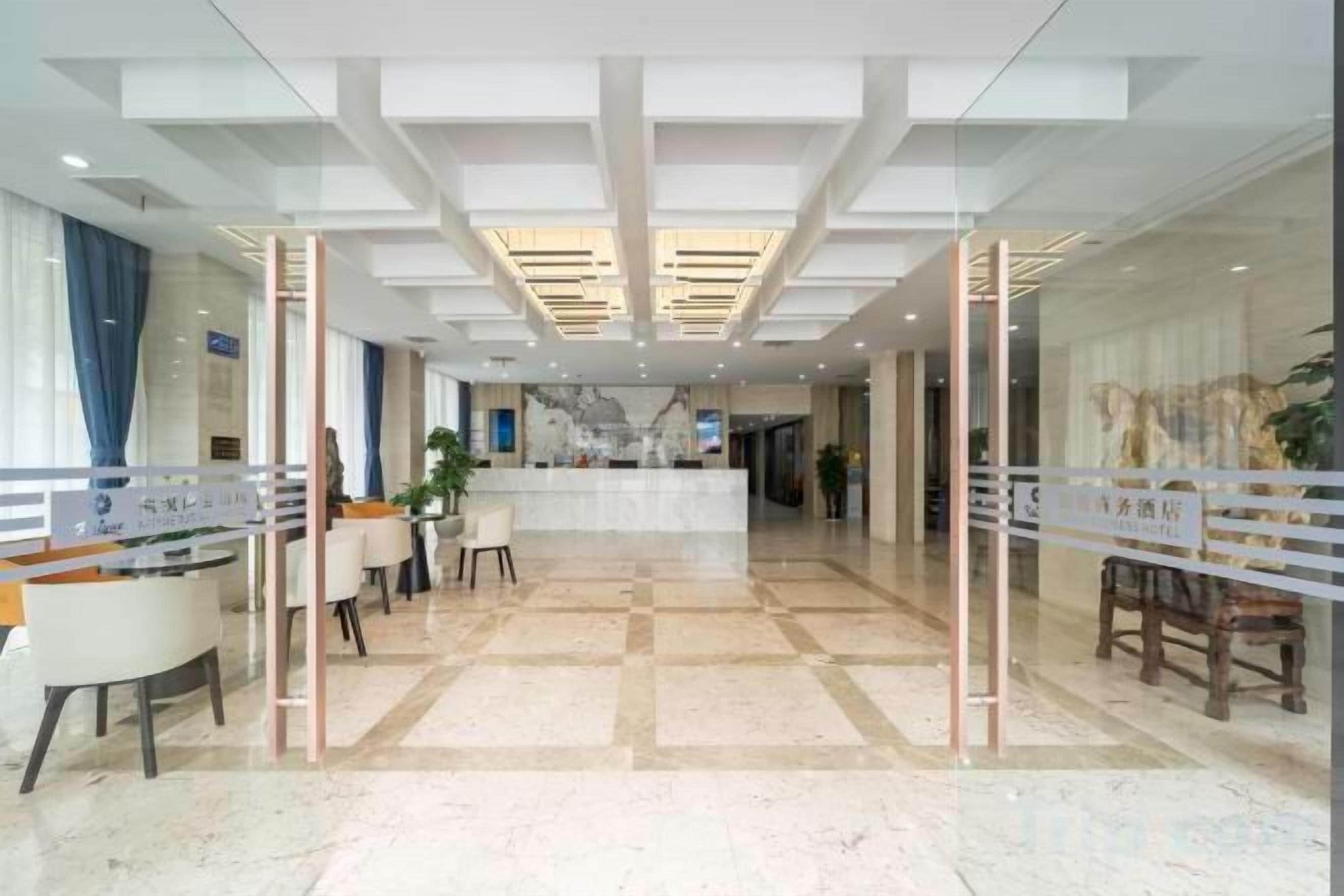 A hotel lobby with a reception desk, seating area, and a check-in counter.