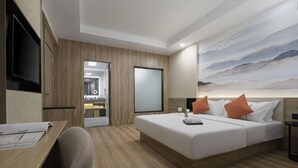 A modern hotel room with a bed, desk, and a painting on the wall. - Kaiyue Business Hotel（Ninefang City Shop,Northmen Road ） (KUNSHAN)