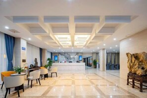 A hotel lobby with a reception desk, seating area, and a large decorative sculpture. - Kaiyue Business Hotel（Ninefang City Shop,Northmen Road ） (KUNSHAN)