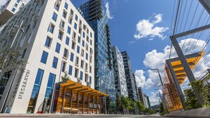 Un bâtiment moderne doté d’une façade en verre et d’une entrée abritée.