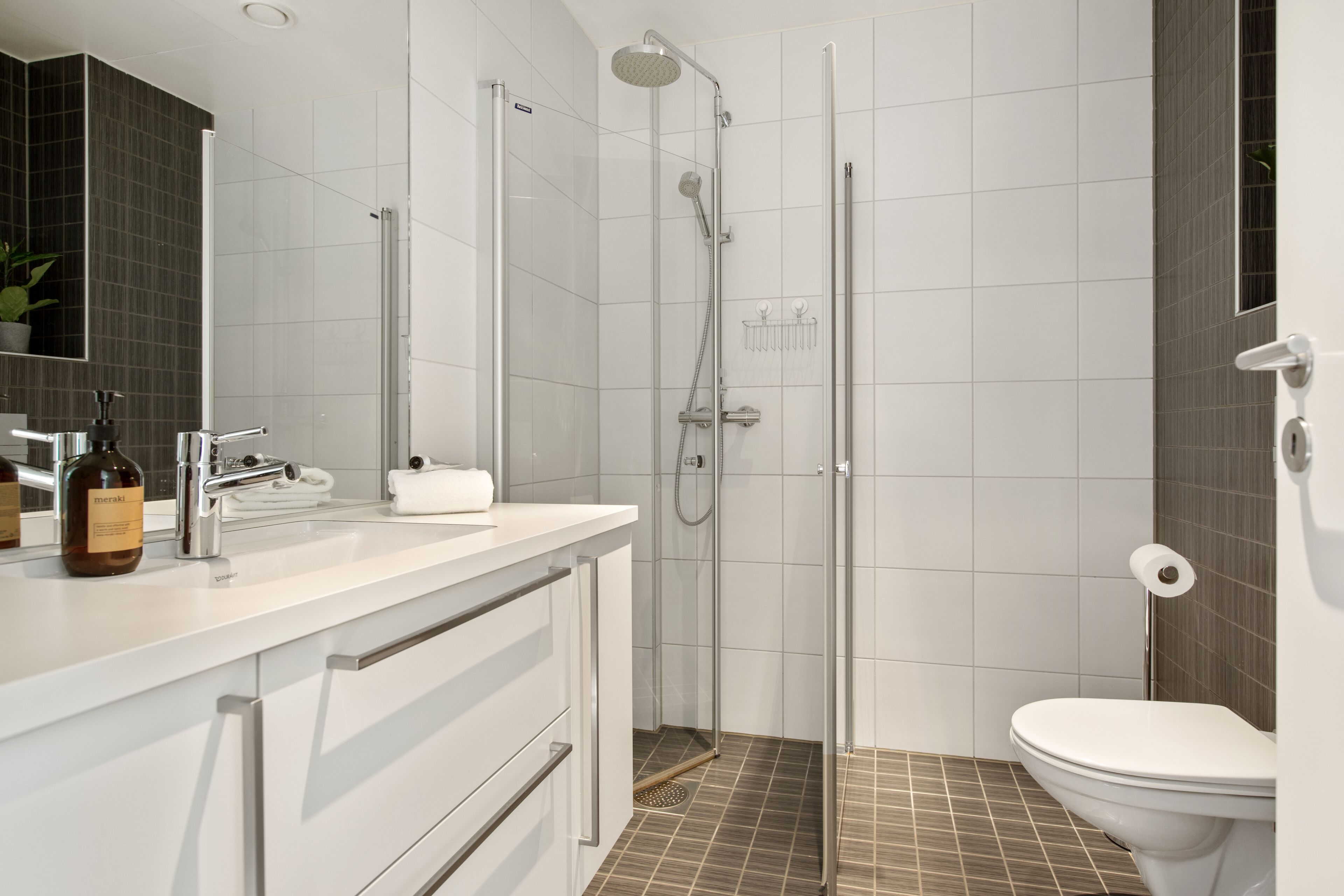 Un baño moderno con ducha, inodoro y lavabo.