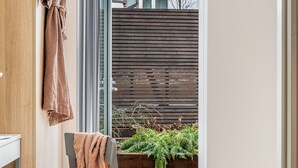 Une salle de bain moderne avec un meuble-lavabo en bois, un porte-serviettes et une chaise sur laquelle est posée une serviette.