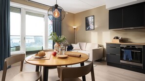 Une cuisine moderne dotée d’un four encastré et d’un coin repas avec une table ronde et des chaises.