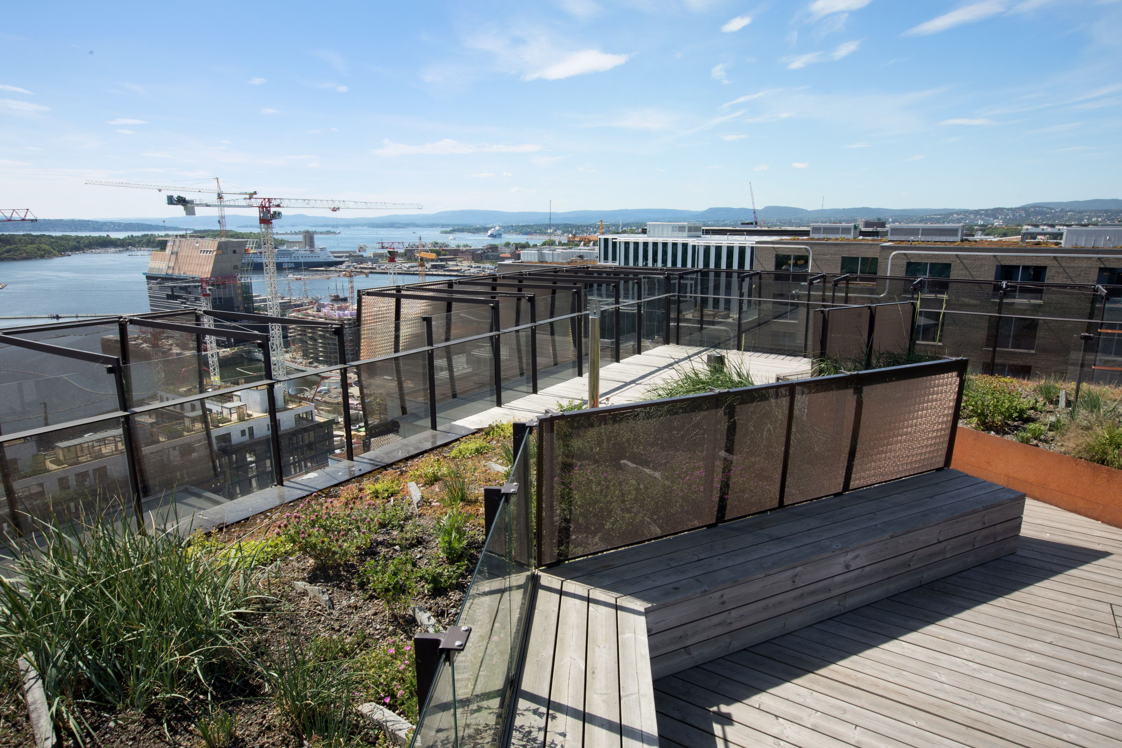 Une terrasse sur le toit offrant une vue sur un chantier de construction et une rivière.