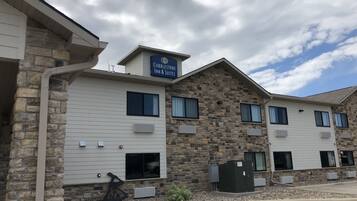 A hotel with a stone facade and multiple windows, including a sign for 'Cobblestone Inn & Suites'.