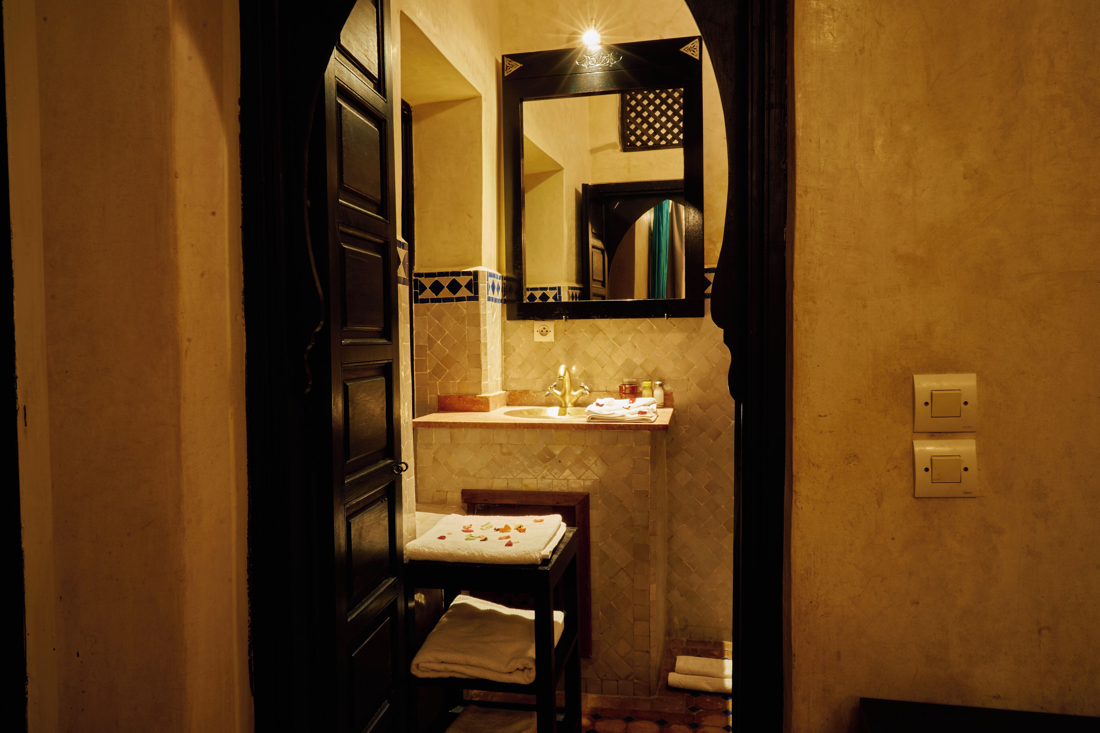 A small bathroom with a mirror, sink, and towel rack.