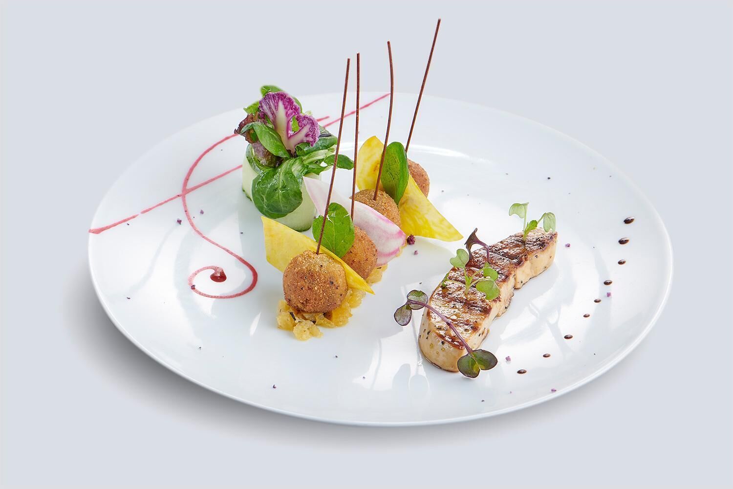 Ein weißer Teller mit verschiedenen Speisen, darunter gegrillter Fisch, eine Teigkugel und etwas Grünzeug.