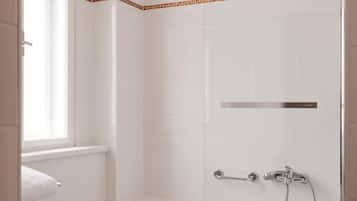 A modern bathroom with a bathtub, toilet, and shower.