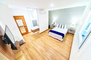 A hotel room with a bed, a desk, a mirror, and a window. - Hotel LP Equipetrol (Santa Cruz)
