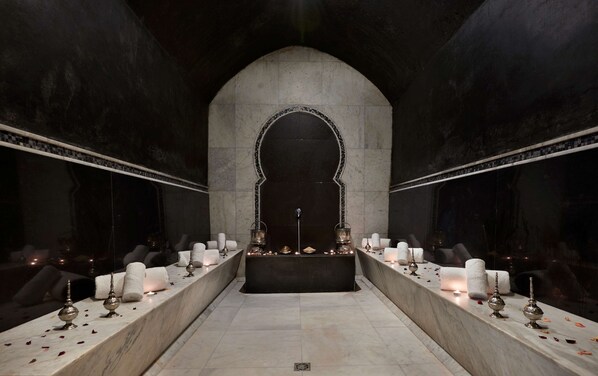A dimly lit, arched corridor with a central altar, candles, and votive lamps, suggesting a ceremonial or religious setting. - Hyatt Place Taghazout Bay (Taghazout)