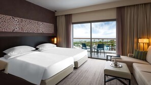 A hotel room with two beds, a balcony with a pool view, and a seating area with a table and chairs. - Hyatt Place Taghazout Bay (Taghazout)