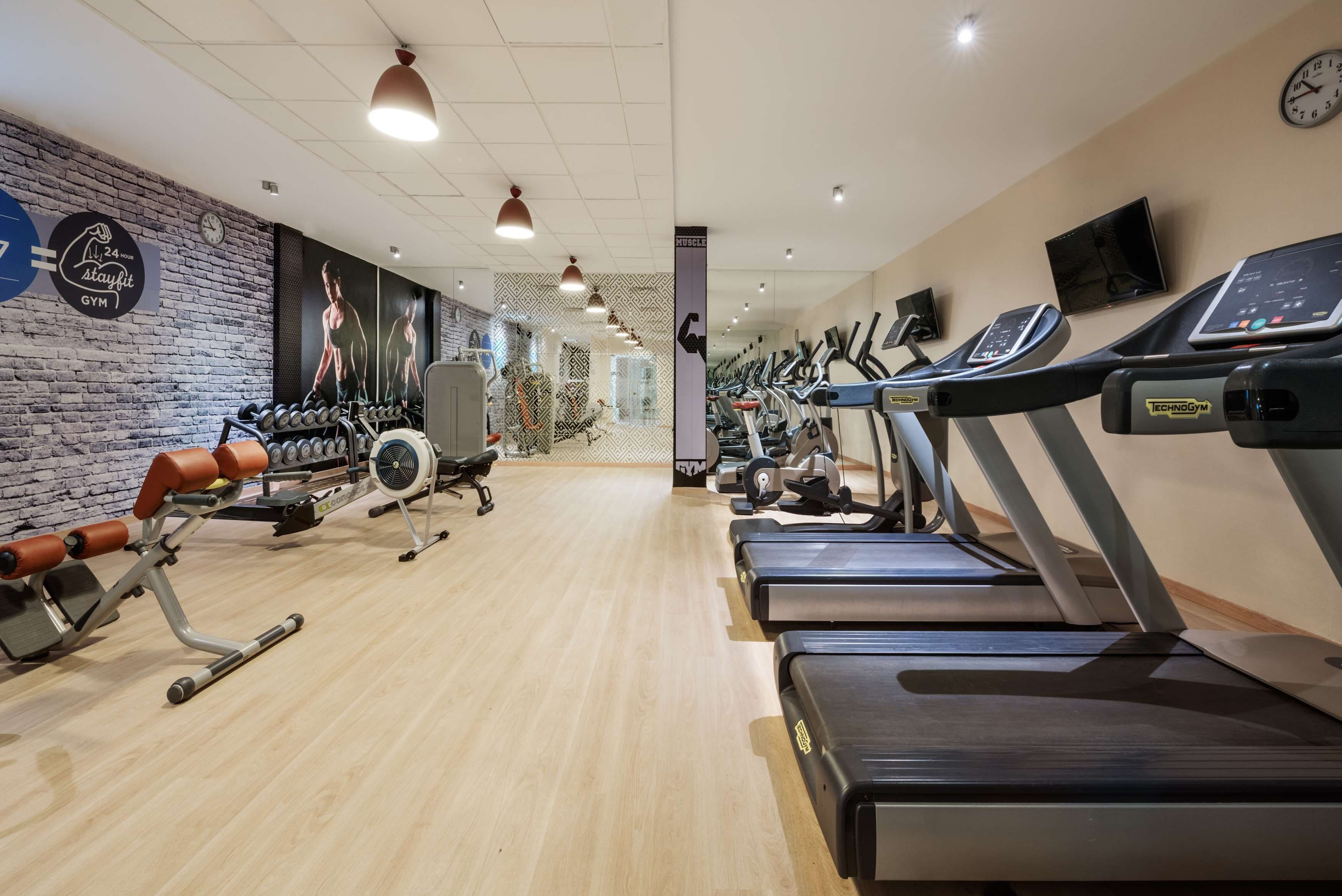 A gym with treadmills, elliptical machines, and weightlifting equipment.