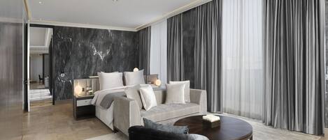 Ein modernes Hotelzimmer mit einem Bett, einem Sofa, einem Couchtisch und einem großen Fenster mit Vorhängen.