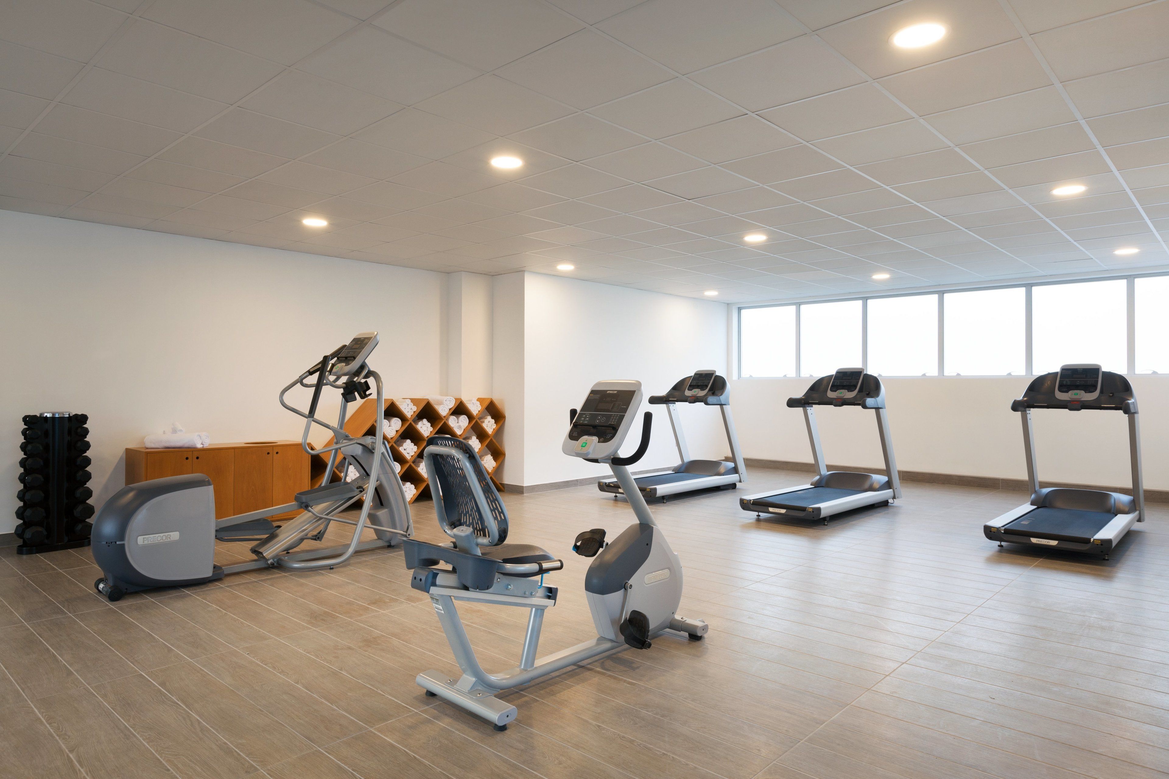 A gym with treadmills, an elliptical, and a stationary bike.