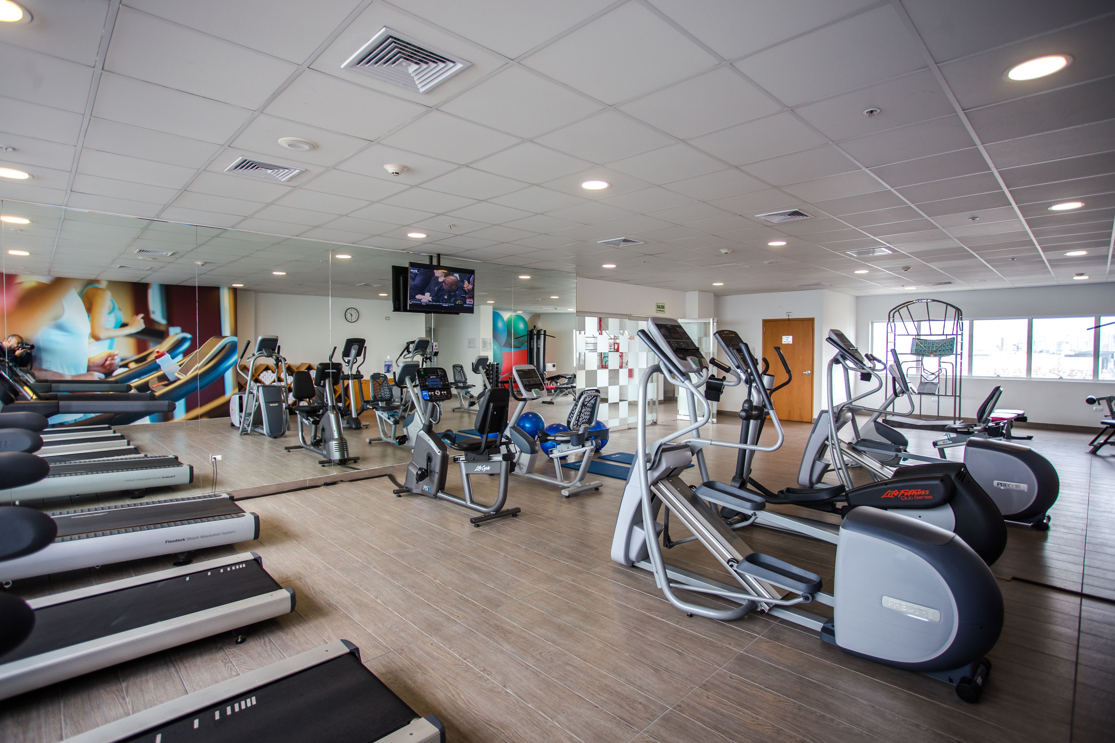 A gym with treadmills, elliptical machines, and stationary bikes.