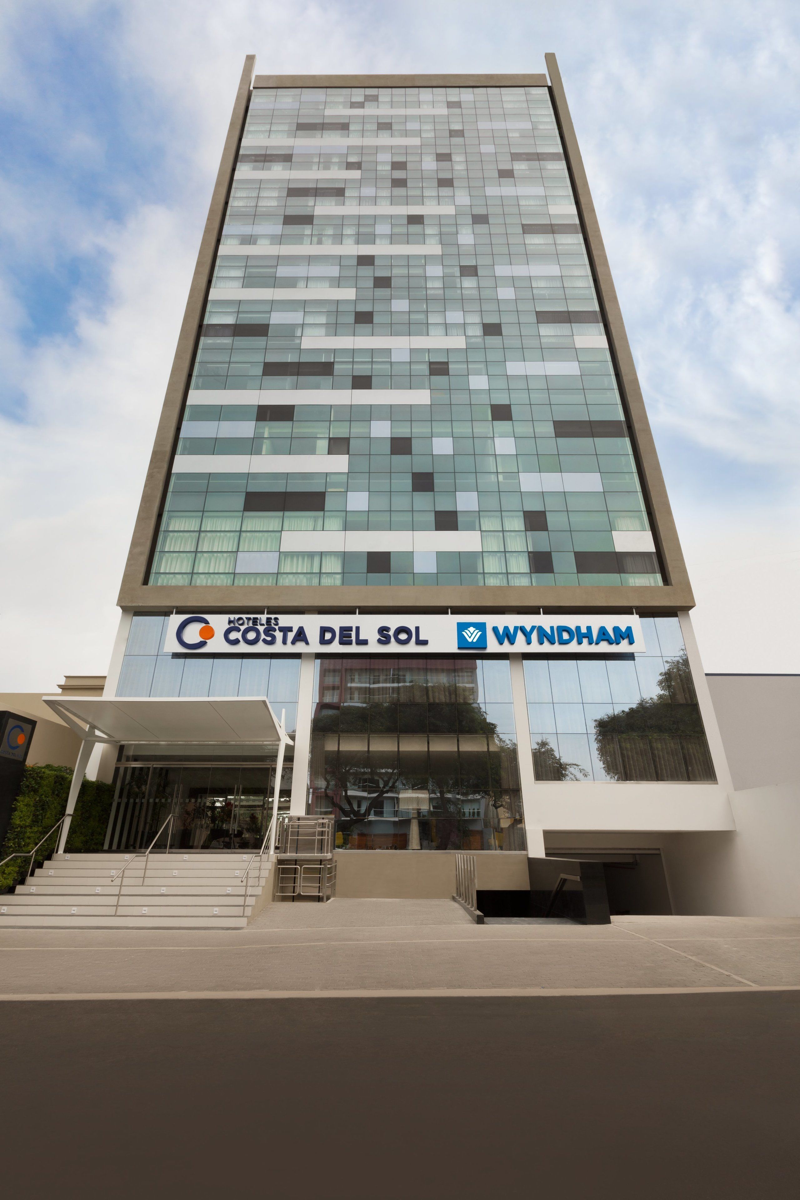 Un moderno edificio de hotel con fachada de vidrio, llamado 'Costa del Sol Wyndham'.