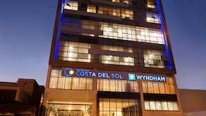 Un moderno edificio de hotel con una entrada destacada y un letrero que dice "HOTELES COSTA DEL SOL WYNDHAM".