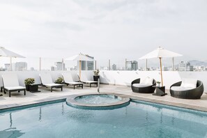 Una piscina al aire libre, sillones reclinables de piscina