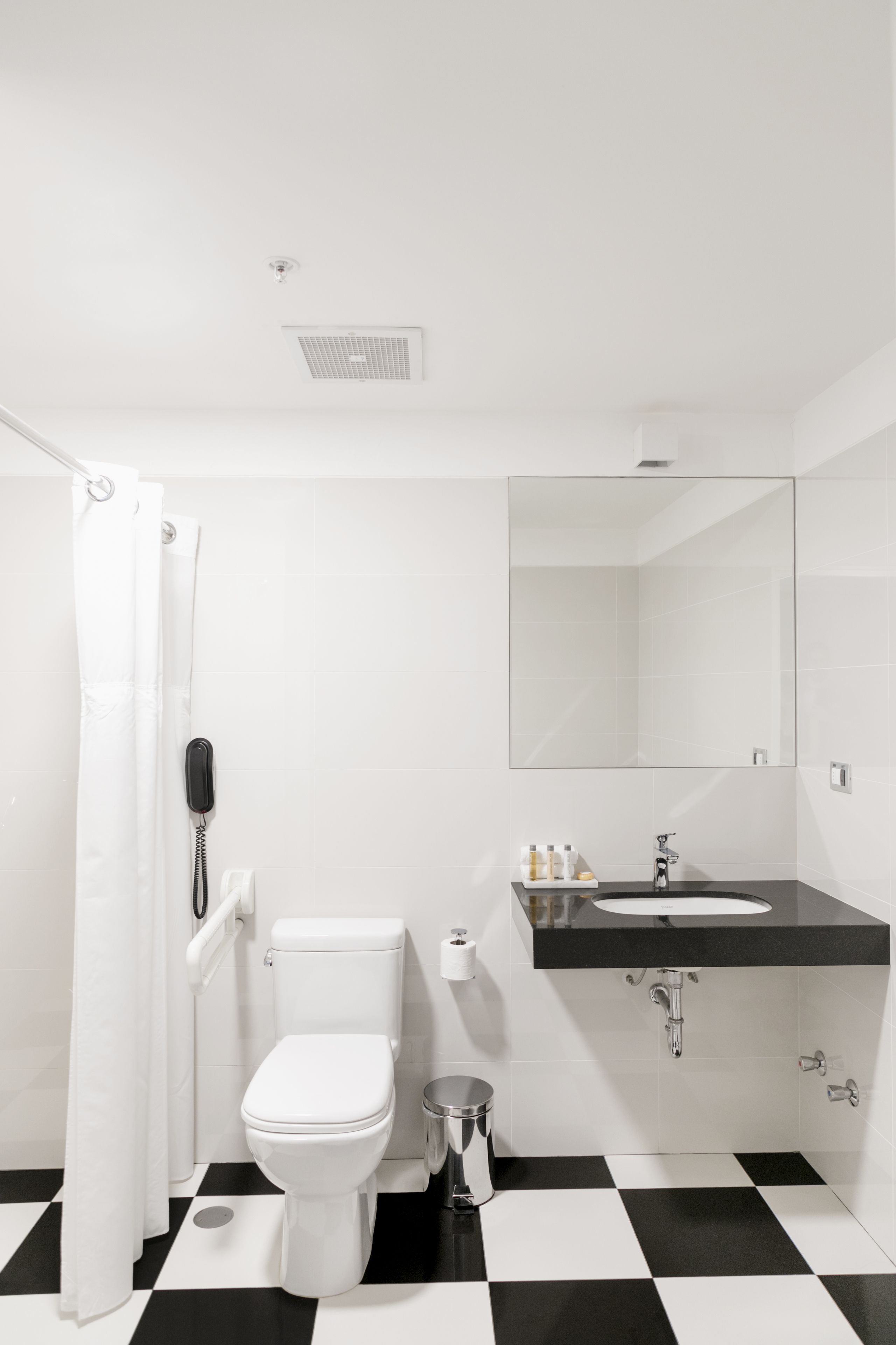 Un baño con inodoro, lavamanos y espejo.