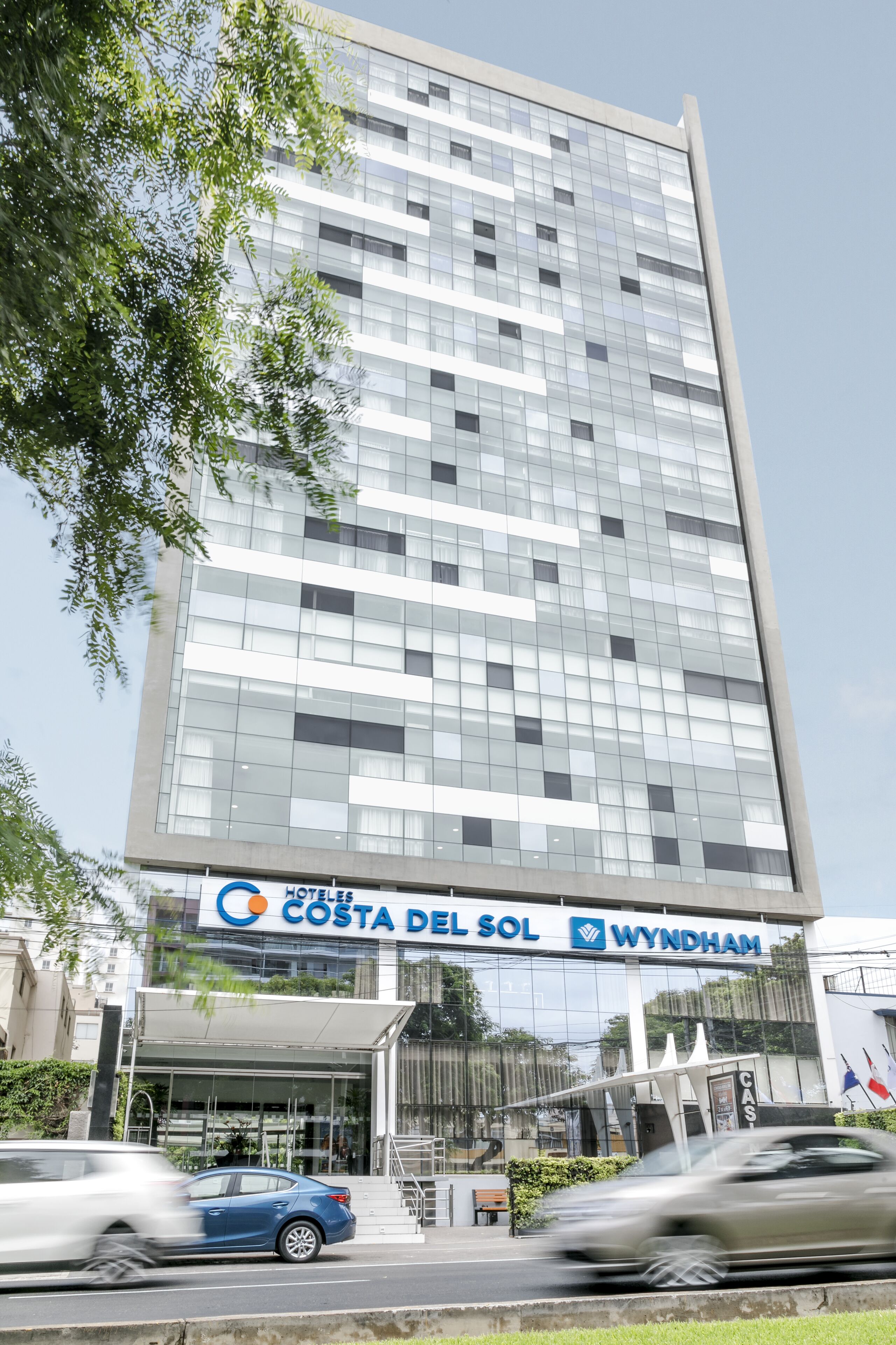 En moderne hotelbygning med en glasfacade og et skilt, der viser "Costa del Sol Wyndham".