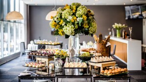 Una mesa de buffet con diversos alimentos y un gran centro de flores.