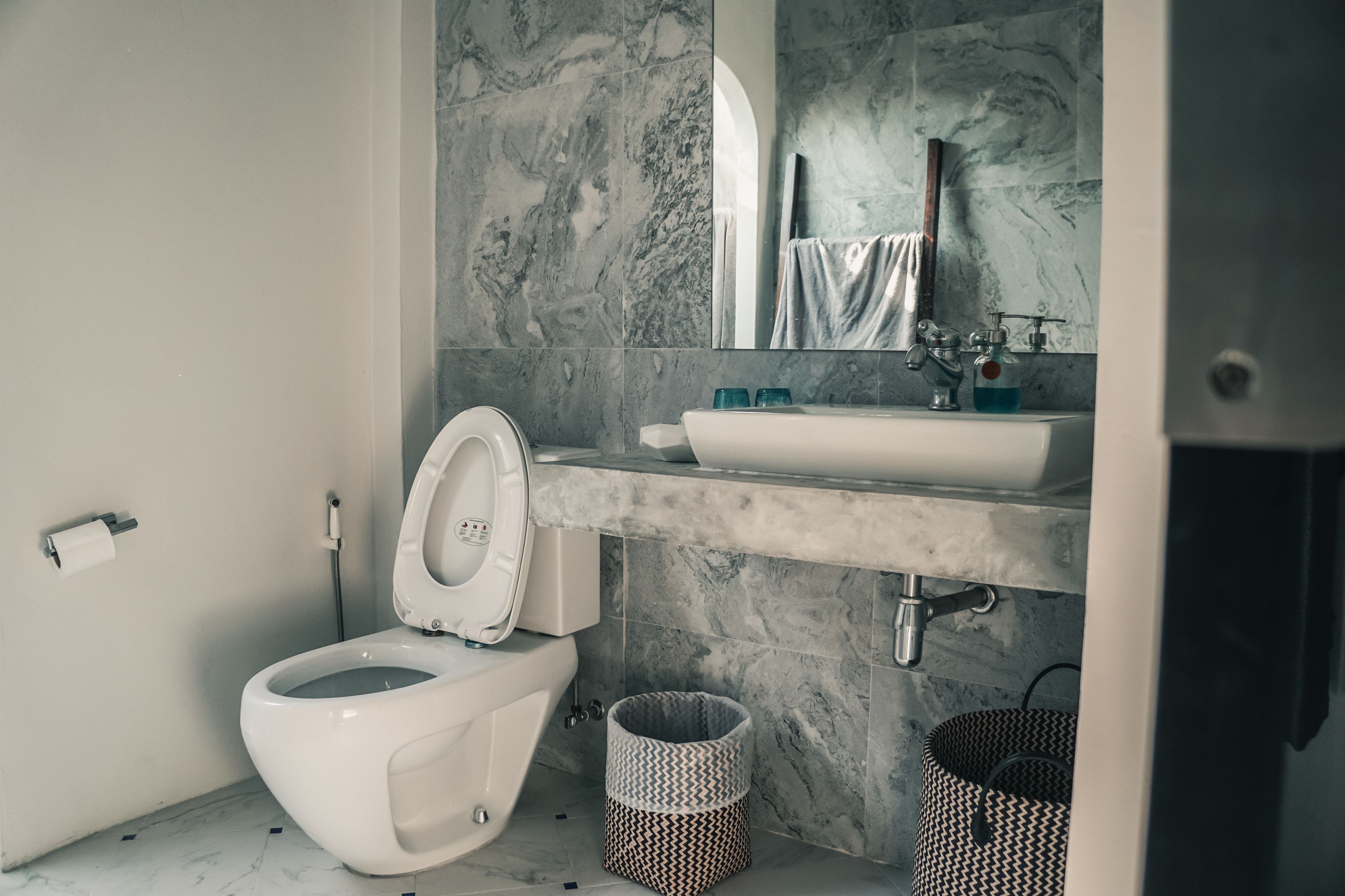 Un bagno moderno con WC, lavabo e pareti in marmo.