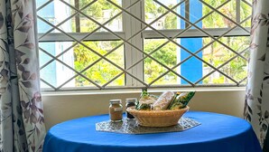 A table with a blue tablecloth, a basket, and jars of sugar and salt. - Skyblue Beach Apartments (Villa)
