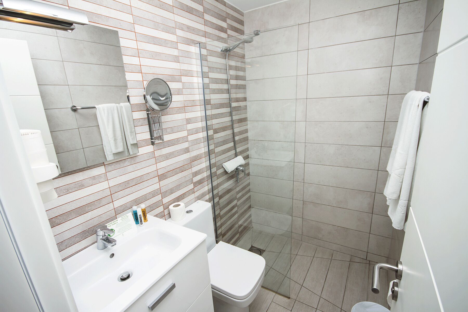 A modern bathroom with a sink, toilet, and shower.