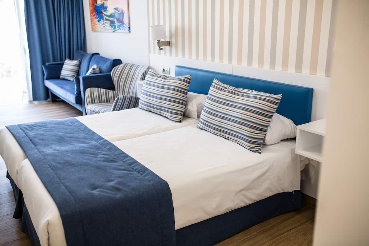 Relax in this inviting space with a large bed, comfortable seating area, and a beautiful painting on the wall.