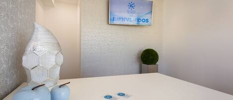 A reception area with a welcome sign, a decorative wall, and a small plant.